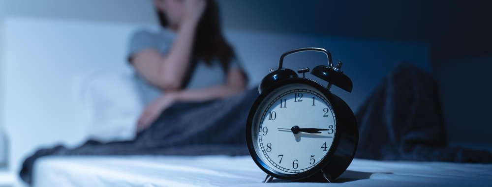 Persona despierta en la cama con dificultad para conciliar el sueño